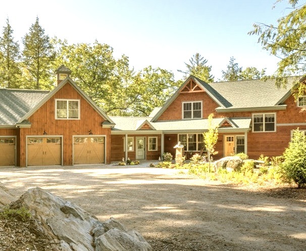 Large mountain style three-story wood exterior home photo with a shingle roof